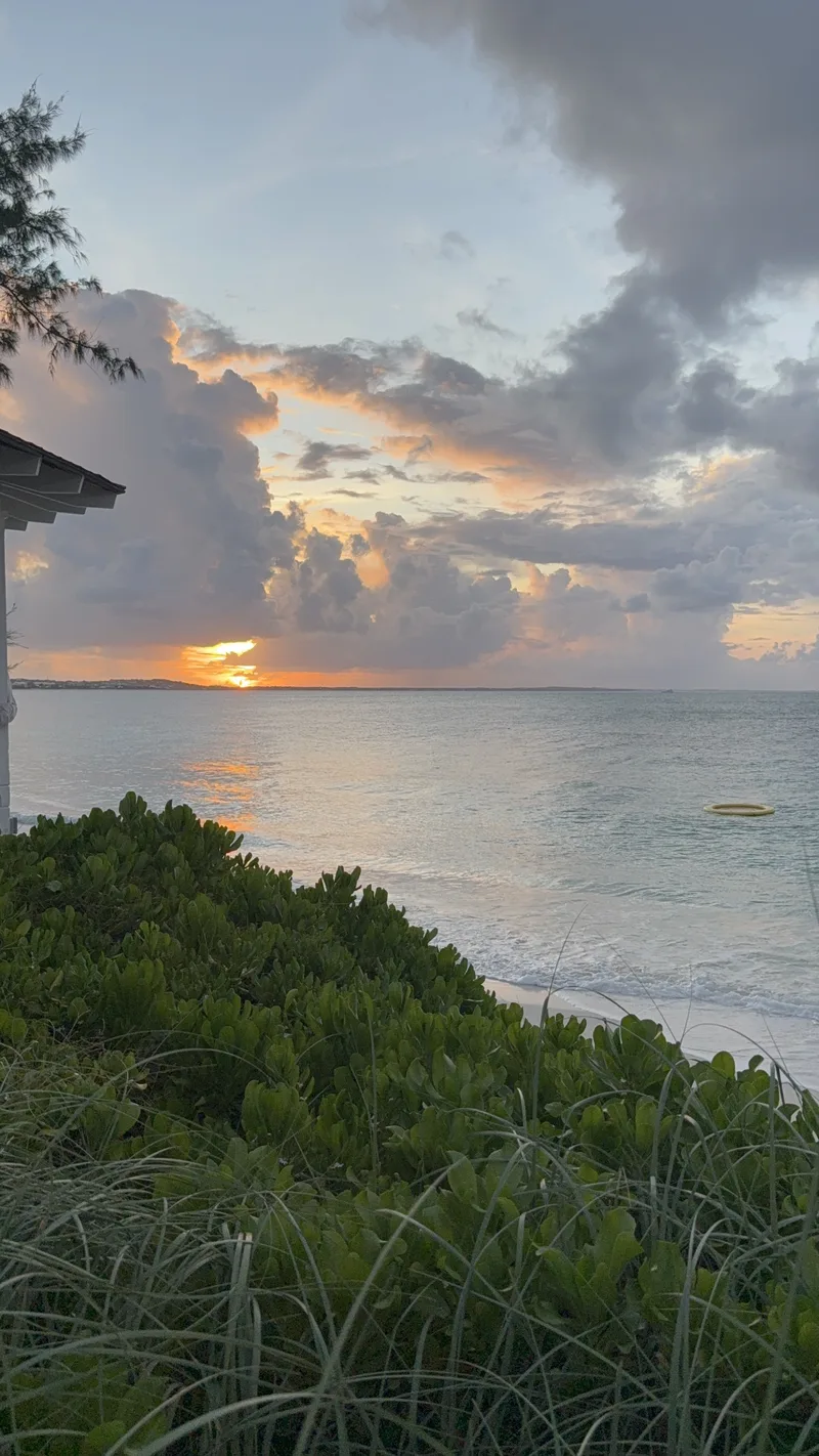 Sandy Caribbean shoreline and ocean at sunset